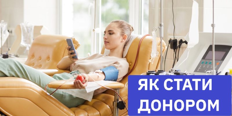 Young female donor lying on the couch and using her mobile phone while donating blood at hospital